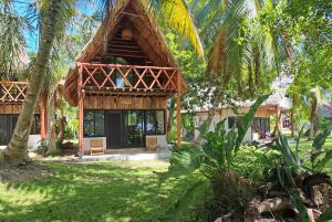 um resort com um edifício de palha com palmeiras em Xanthus Hotel em Huay Pix