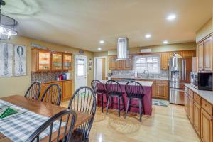 - une cuisine avec des placards en bois, une table et des chaises dans l'établissement Greers Ferry Lake Vacation Rental with Porch and View!, à Heber Springs