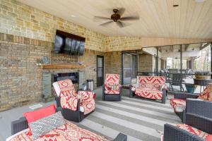 Elle comprend une terrasse avec des chaises, une cheminée et une télévision. dans l'établissement Greers Ferry Lake Vacation Rental with Porch and View!, à Heber Springs