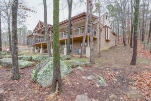 una gran casa en el bosque con árboles en Greers Ferry Lake Vacation Rental with Porch and View!, en Heber Springs