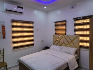 a bedroom with a bed and two windows at B&Y ROYAL BAR & LOUNGE ADIGBE ROAD ABEOKUTA NEAR ADIGBE POLICE STATION AFTER PANSEKE in Abeokuta