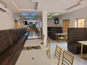 een restaurant met banken, tafels en stoelen bij B&Y ROYAL BAR & LOUNGE ADIGBE ROAD ABEOKUTA NEAR ADIGBE POLICE STATION AFTER PANSEKE in Abeokuta