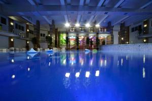 uma grande piscina com luzes azuis num edifício em Evan cozy flat with indoor pool Militari Residence em Roşu