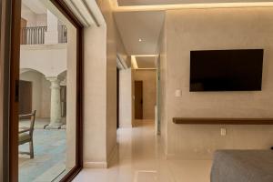 a room with a television and a living room at Casa Quiote Hotel Boutique City Center based - Adults Only in Oaxaca City