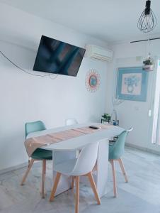 a white dining room with a table and chairs at Apartamento con wifi, mascotas bienvenidas in Benidorm