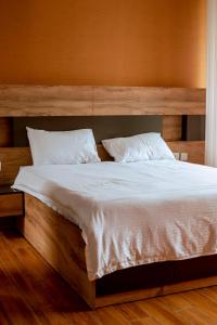 - une chambre dotée d'un grand lit avec des draps et des oreillers blancs dans l'établissement Vista Heights Residence, à Kigali