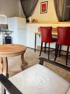 a kitchen with a table and two red chairs and a table at Work, Rest and Play: WiFi, TV and Backyard Bliss in North Miami Beach
