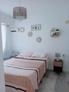 a white bedroom with a bed and a chandelier at Apartamento con wifi, mascotas bienvenidas in Benidorm
