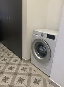 una lavatrice in una camera con pavimento piastrellato di Byt ve městě Praha 2 a Praga