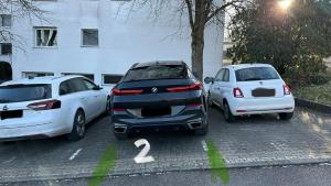 dos autos están estacionados en un estacionamiento en Apartment Arianna Sachsenheim, en Sachsenheim