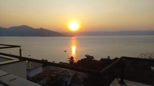 un coucher de soleil sur l'eau depuis une maison dans l'établissement Casa estrada da torre, à Ilhabela