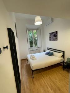 a bedroom with a white bed and a window at La Casa Romana in Rome