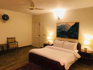 a bedroom with a bed and a painting on the wall at The Sarai Suites, Murree in Murree