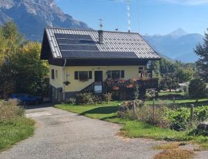 a house with solar panels on the roof at Les Balcons du Mont-Blanc : Appartement centre village in Cordon