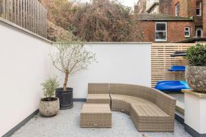 a patio with a couch and a small tree at 3 Bedroom, 3 bathroom large flat with sea views! in Hastings