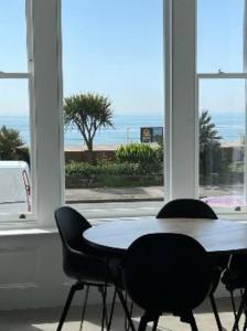 a table and two chairs in a room with a window at 3 Bedroom, 3 bathroom large flat with sea views! in Hastings