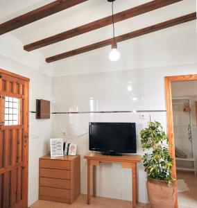 - un salon avec une télévision sur une table en bois dans l'établissement La Bombonera, à Catadau