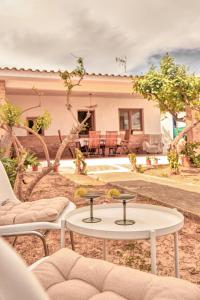 a patio with two chairs and a table in front of a house at La Bombonera in Catadau