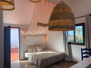 a bedroom with a bed and a large window at Casa Cocolores in Villaverde