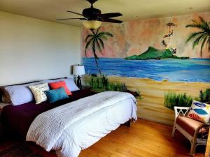um quarto com uma cama com um quadro na parede em Oceanfront true 2 bedroom w/lanai on Molokai em Ualapue