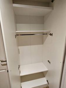 a white closet with white shelves in a room at Entire en-suite flat in Windsor home with free parking in Windsor