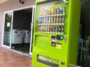 a green vending machine with soda bottles on it at R2 Apartment Service in Nakhon Ratchasima