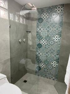 y baño con ducha y puerta de cristal. en Excellent House (Laureles) Jacuzzi and 6 Rooms, en Medellín