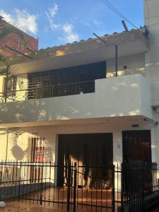 a white building with a fence in front of it at Excellent House (Laureles) Jacuzzi and 6 Rooms in Medellín