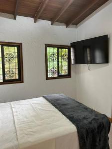 a bedroom with a bed with two windows in it at Excellent House (Laureles) Jacuzzi and 6 Rooms in Medellín