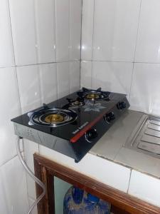 - une petite cuisine équipée de plaques de cuisson noires dans l'établissement Independent apartment in a villa, à Ouagadougou