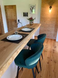 een keuken met een houten tafel met stoelen en wijnglazen bij Bergromantik Apartments Fritzenlehen in Berchtesgaden