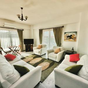 ein Wohnzimmer mit weißen Sofas und einem Fernseher in der Unterkunft Derya'ca in Kaş