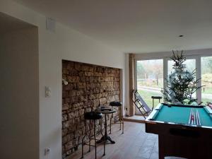 a room with a pool table and a brick wall at Les chambres du Haras St Georges in Athesans