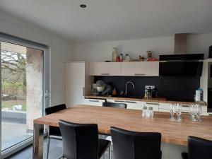 - une cuisine avec une table et des chaises en bois dans l'établissement Les chambres du Haras St Georges, à Athesans