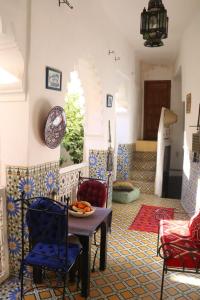 - un salon avec une table et des chaises dans l'établissement RIAD Redous, à Marrakech