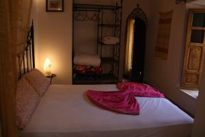 a bed with a red blanket on top of it at RIAD Redous in Marrakesh