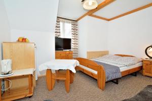 1 dormitorio con cama, mesa y TV en Willa Świerk - Panorama Tatr en Zakopane