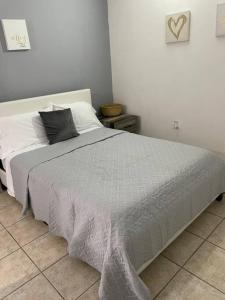 a white bed with a black pillow on top of it at The Perfect Studio in Arecibo