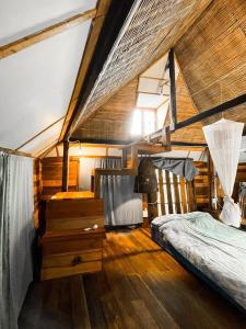 um quarto com uma cama e piso em madeira em Monsamkien Farmstay em Phayao