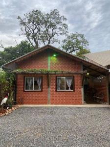 uma pequena casa de tijolos vermelhos com duas janelas em Tarumã Challes, Chalé para casais em Bonito