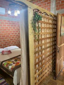 um quarto com uma cama e uma parede de madeira em Tarumã Challes, Chalé para casais em Bonito