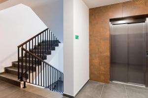 a hallway with a staircase and a metal elevator at Witkacy Apartament in Słupsk