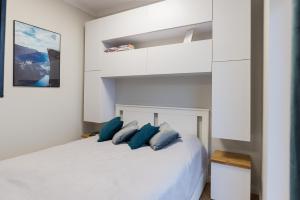 um quarto com uma cama branca e almofadas azuis em Witkacy Apartament em Słupsk