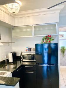 una cocina con nevera con una planta en Beach Aqualina Apartments en Fort Lauderdale