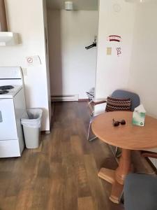 een kleine kamer met een tafel en een keuken bij #17 Snooze in Wisconsin Rapids