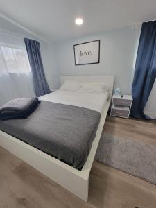 ein Schlafzimmer mit einem weißen Bett mit den Worten Liebe in der Unterkunft Work, Rest and Play: WiFi, TV and Backyard Bliss in North Miami Beach
