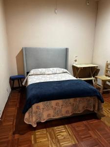 Un dormitorio con una cama con una manta azul. en Casa Yolcatl, en Ciudad de México