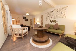 ein Wohnzimmer mit einem Sofa und einem Tisch in der Unterkunft la grande cabane du Blanc Ruxel in Xonrupt-Longemer