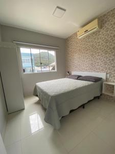 um quarto com uma cama grande e uma janela em Residencial Mariano 5 em Florianópolis