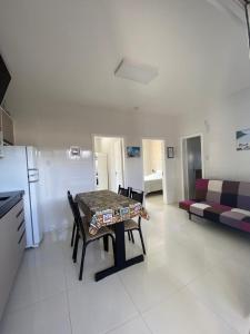 a kitchen with a table and chairs and a couch at Residencial Mariano 5 in Florianópolis